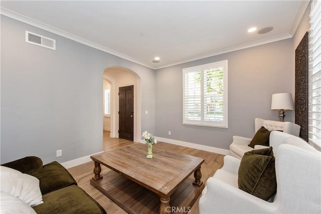 living room with light wood-type flooring and ornamental molding