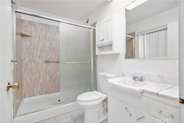 bathroom featuring a shower with door, tile patterned floors, vanity, and toilet