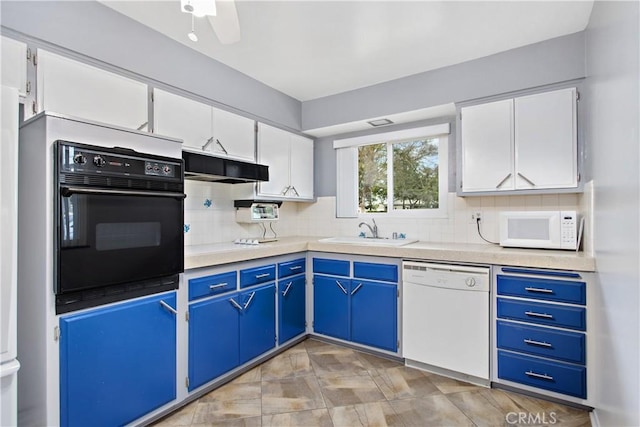 kitchen with white appliances, white cabinets, sink, backsplash, and blue cabinets