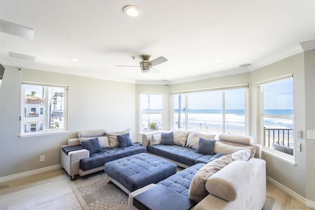 living room featuring a water view, light wood-type flooring, and plenty of natural light