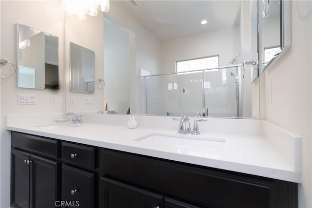 bathroom featuring vanity and a shower with door