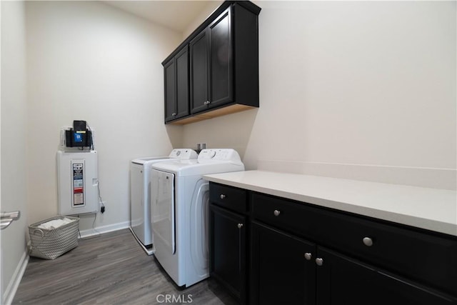 washroom featuring dark wood-type flooring, cabinets, and washing machine and clothes dryer