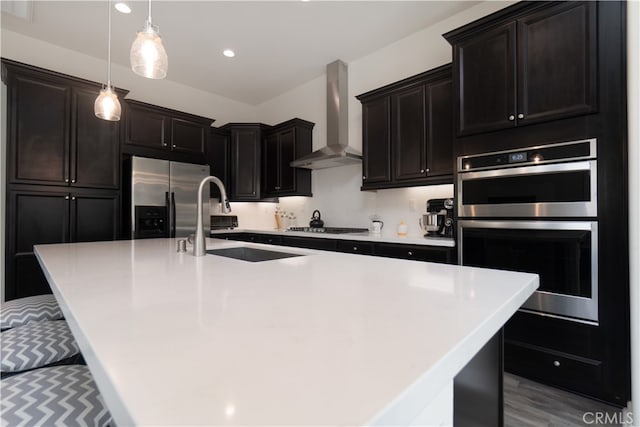 11121 Fourleaf Ct, Corona, CA 92883 - kitchen with wall chimney range hood, stainless steel appliances, a large island with sink, pendant lighting, and light countertops