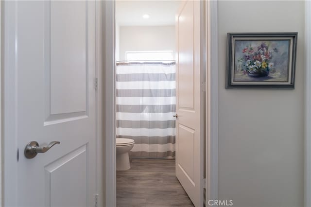 bathroom featuring hardwood / wood-style floors, toilet, and walk in shower