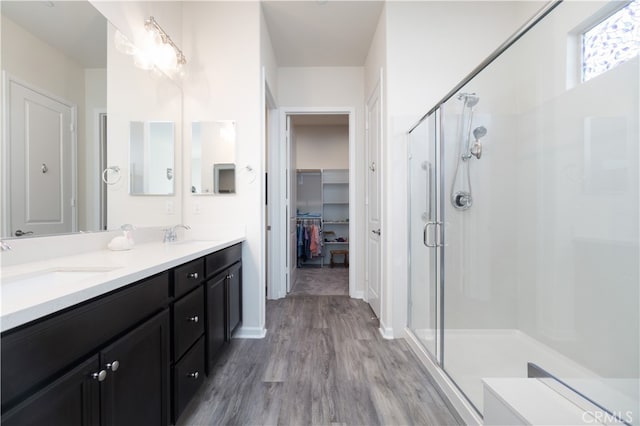 bathroom with vanity, wood-type flooring, and a shower with door