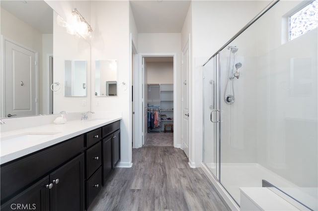 11121 Fourleaf Ct, Corona, CA 92883 - full bathroom featuring a stall shower, wood finished floors, double vanity, and a walk in closet