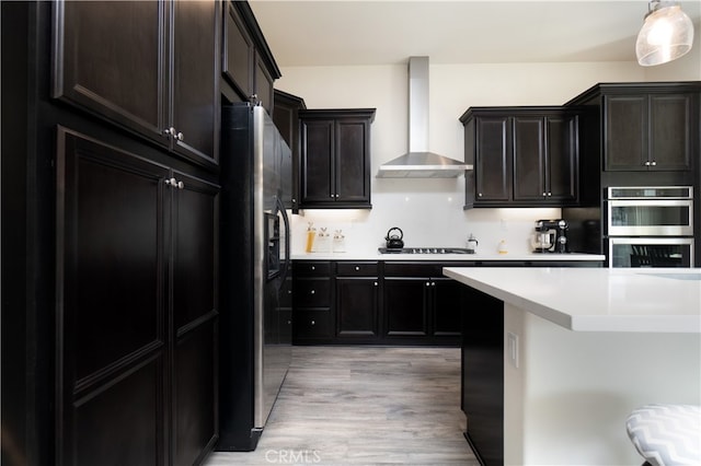 11121 Fourleaf Ct, Corona, CA 92883 - kitchen featuring wall chimney range hood, fridge with ice dispenser, double oven, light wood finished floors, and light countertops