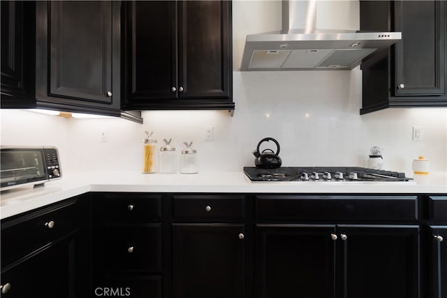 11121 Fourleaf Ct, Corona, CA 92883 - kitchen featuring wall chimney exhaust hood, dark cabinetry, and light countertops