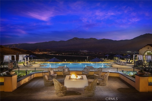 11121 Fourleaf Ct, Corona, CA 92883 - pool at dusk featuring a mountain view, a community pool, and a fire pit
