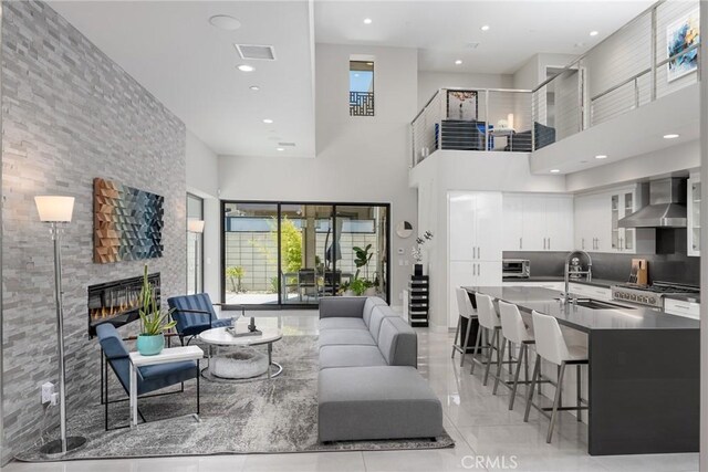 living room with a high ceiling, sink, and a fireplace