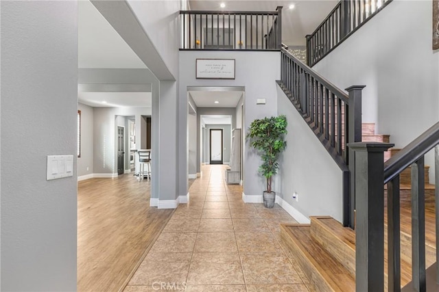 foyer featuring light wood-type flooring and a high ceiling