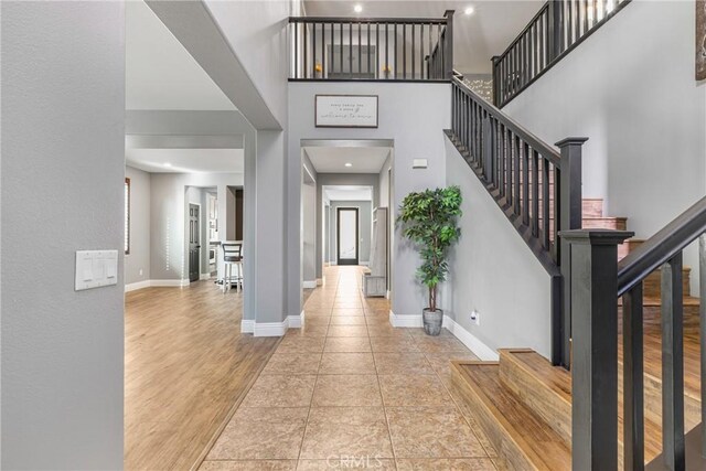 foyer with a towering ceiling and light hardwood / wood-style floors