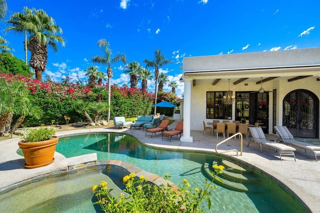 view of pool with a patio area, an in ground hot tub, and french doors