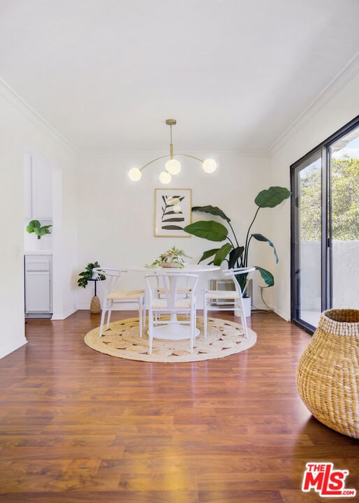 dining area featuring dark hardwood / wood-style flooring and crown molding