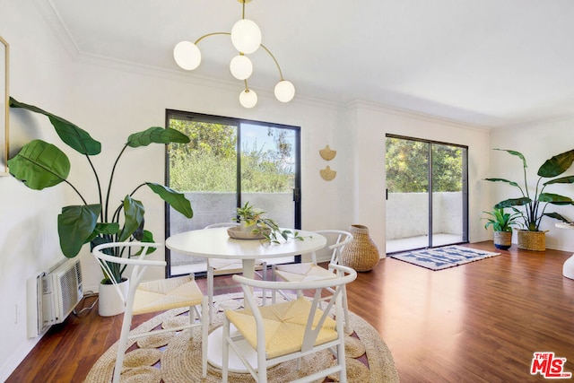 dining room featuring a wall unit AC, dark hardwood / wood-style floors, and crown molding