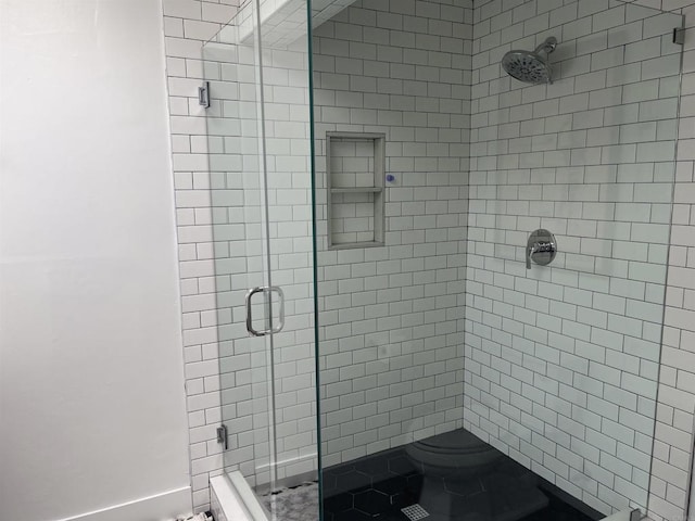 bathroom with an enclosed shower and toilet