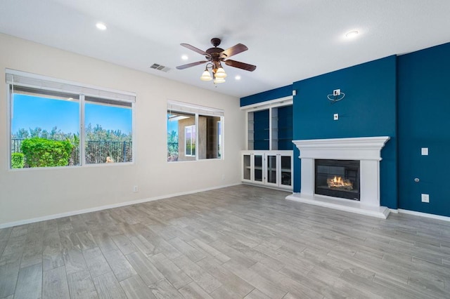 unfurnished living room with ceiling fan and light hardwood / wood-style flooring