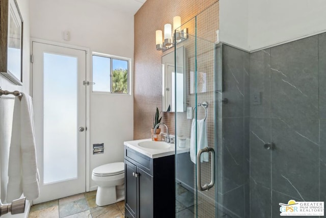 bathroom featuring toilet, a shower with door, and vanity