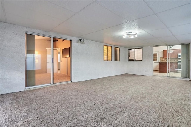 spare room with carpet floors and a drop ceiling