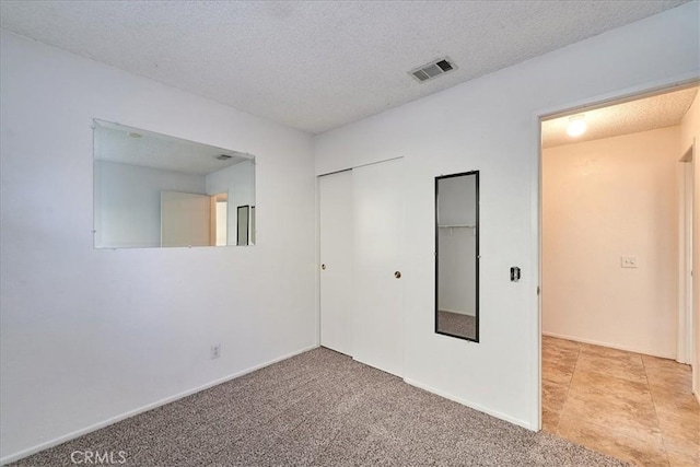 carpeted spare room featuring a textured ceiling