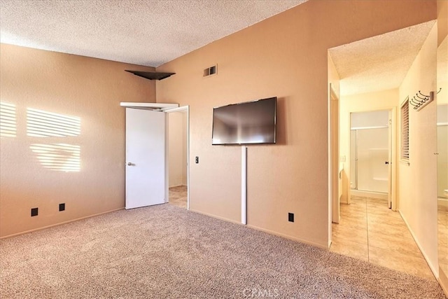 unfurnished bedroom featuring a textured ceiling and light carpet