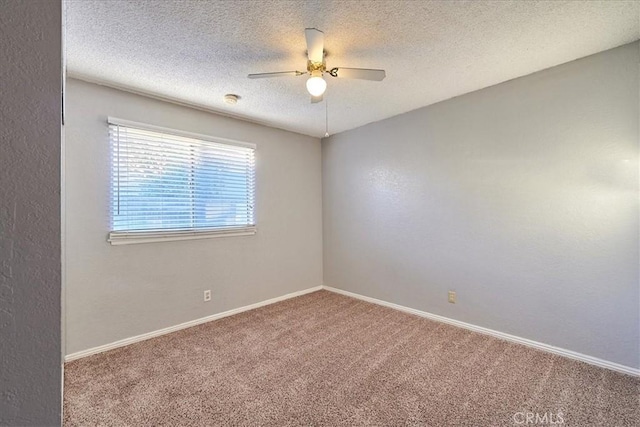 carpeted spare room with a textured ceiling and ceiling fan