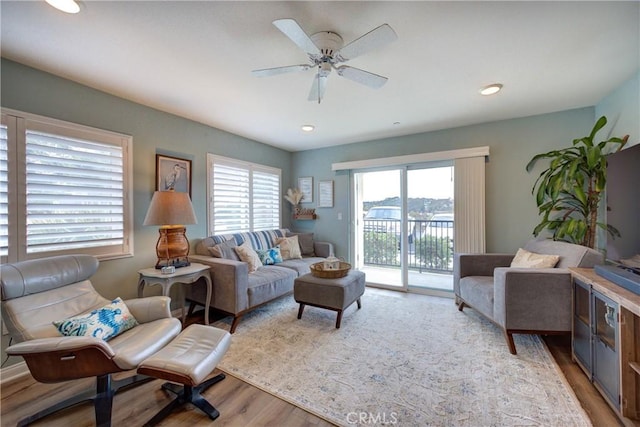 living room with light wood-type flooring and ceiling fan