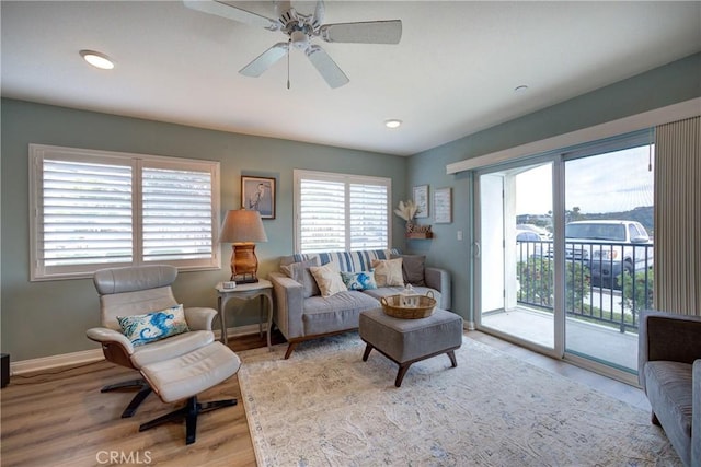 living room featuring ceiling fan and light hardwood / wood-style flooring