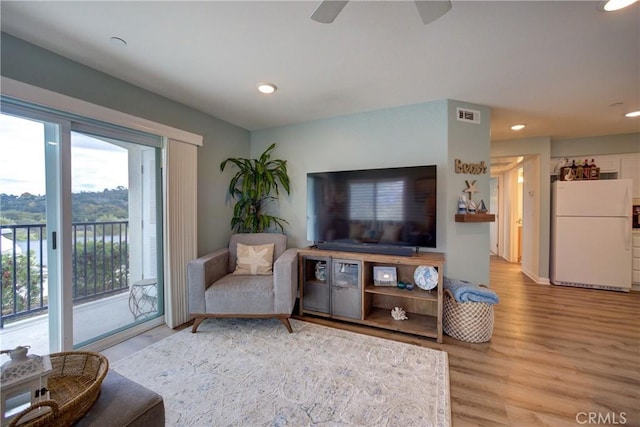 living room with ceiling fan and light hardwood / wood-style floors