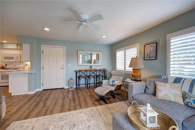 living room with ceiling fan and light hardwood / wood-style flooring