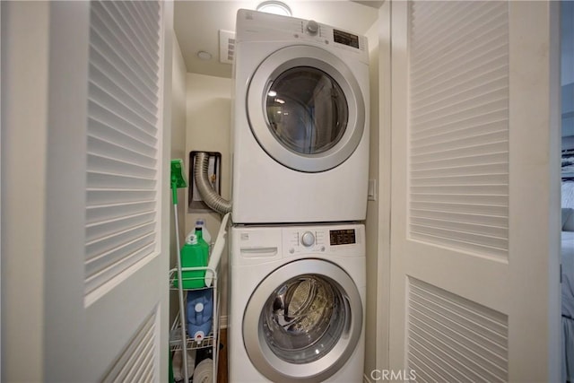 laundry room featuring stacked washer / drying machine