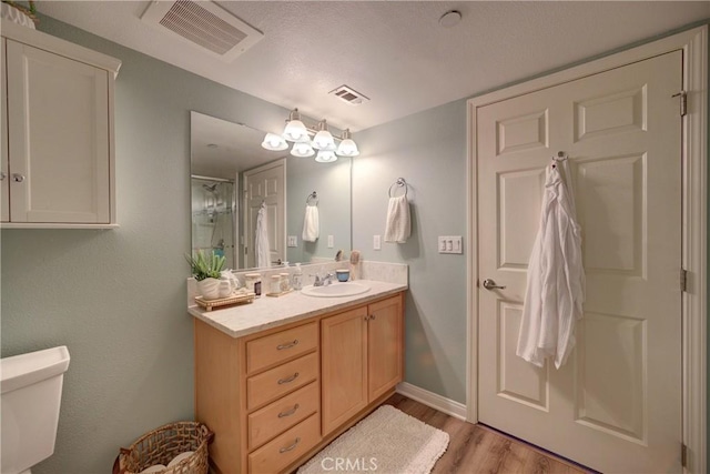 bathroom featuring a shower with door, wood-type flooring, toilet, and vanity