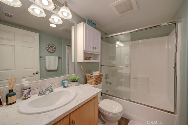 full bathroom featuring toilet, enclosed tub / shower combo, and vanity