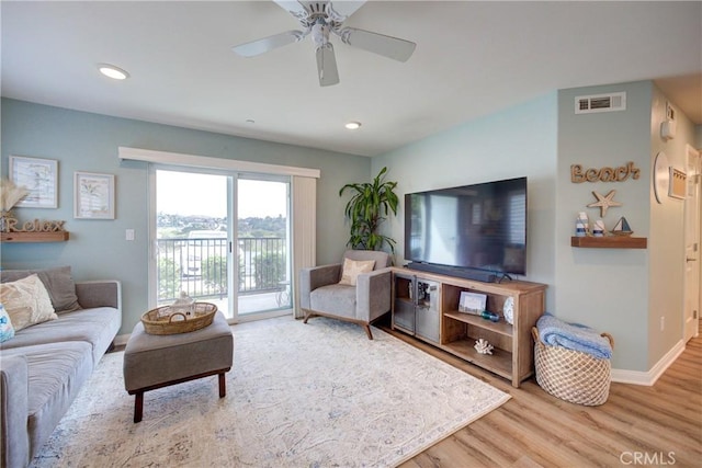 living room with ceiling fan and light wood-type flooring