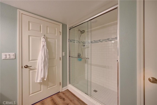 bathroom featuring hardwood / wood-style floors and a shower with door