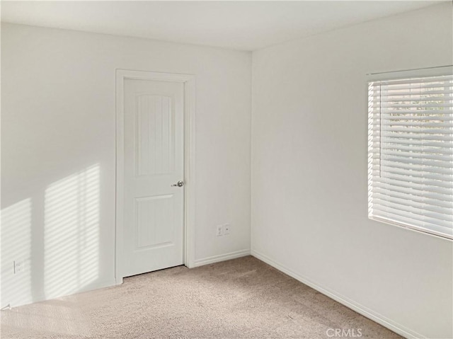 spare room with plenty of natural light and light colored carpet