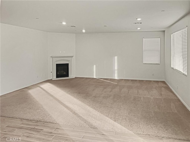 unfurnished living room featuring light colored carpet