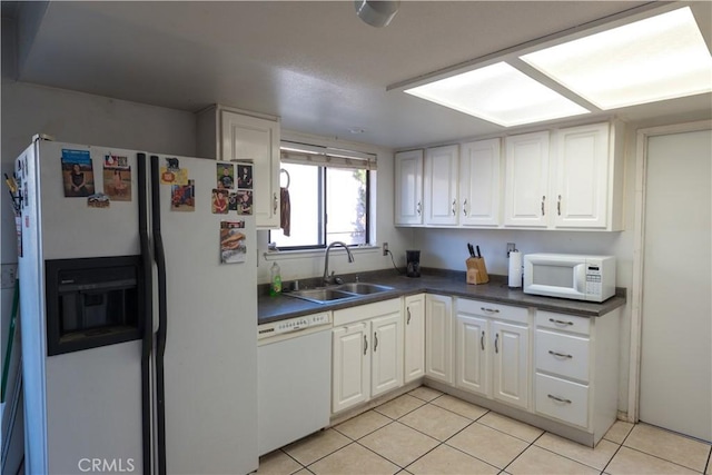 kitchen with white cabinetry, sink, white appliances, and light tile patterned flooring