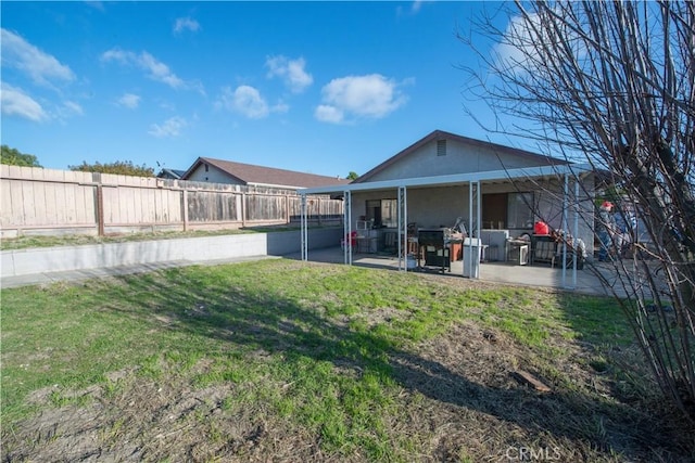 rear view of house featuring a yard and a patio area