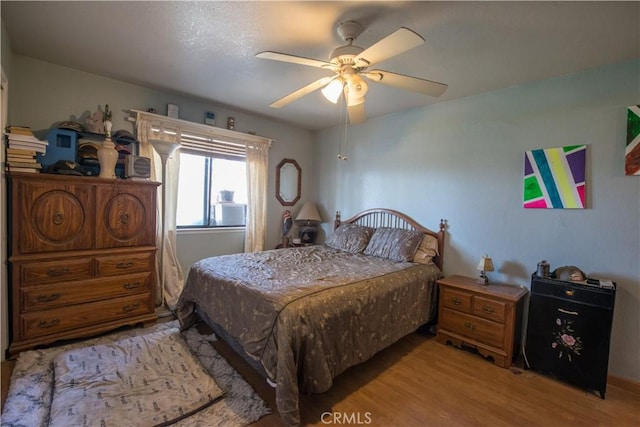 bedroom with light hardwood / wood-style flooring and ceiling fan