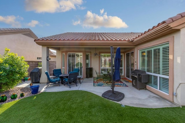 rear view of property featuring a lawn and a patio area