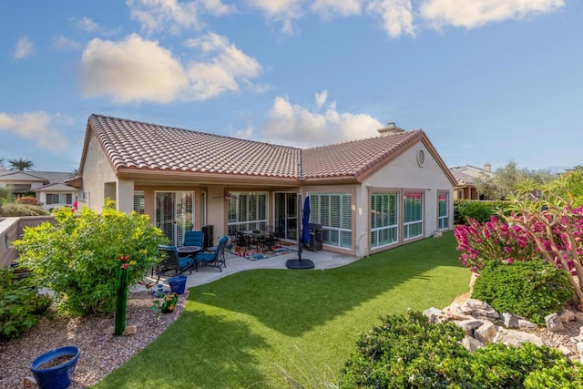 back of house featuring a lawn and a patio area