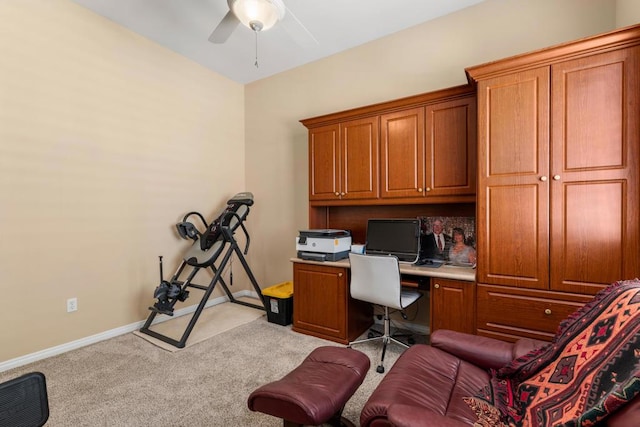 office space with light carpet, ceiling fan, and built in desk