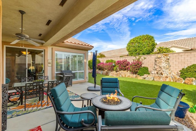 view of patio with ceiling fan, an outdoor fire pit, and area for grilling