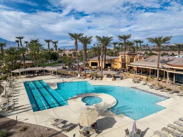 view of pool with a hot tub and a patio