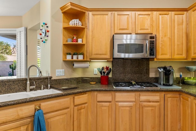 kitchen featuring sink, dark stone countertops, and stainless steel appliances