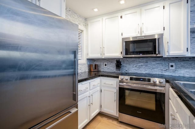 kitchen with appliances with stainless steel finishes, decorative backsplash, and white cabinetry