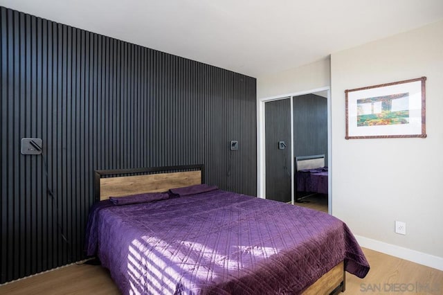 bedroom with wood-type flooring and a closet