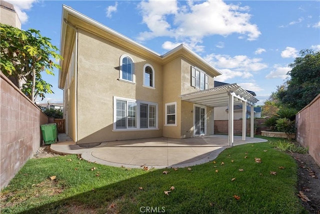 back of property with a pergola, a patio area, and a lawn