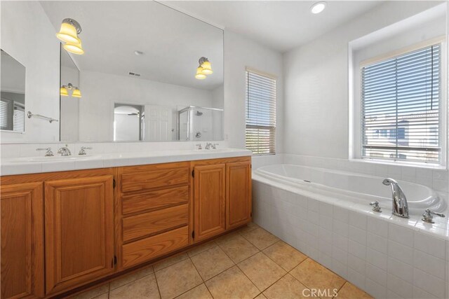 bathroom with tile patterned floors, vanity, and shower with separate bathtub